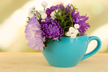 Beautiful bouquet of bright flowers in color mug,