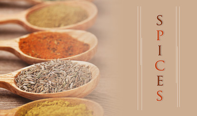 Assortment of spices in wooden spoons on wooden background