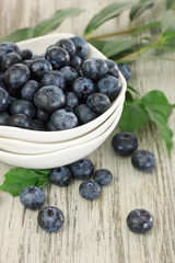 Blueberries in bowls on wooden table