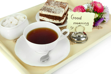 Cup of tea with cakes on wooden tray isolated on white