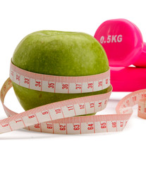 An apple, a measuring tape and dunbbell