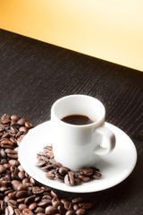 white cup with coffee near coffee beans