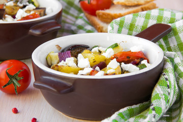 Baked stew of eggplant, zucchini, potatoes and onions with feta
