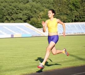 Obraz premium Girl running on the stadium track