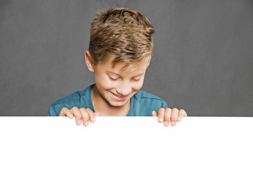 Child looking over white Wall