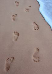 Fototapeta na wymiar human footprints on the beach sand