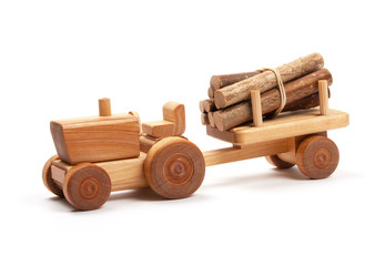 Wooden toy tractor with trailer on white