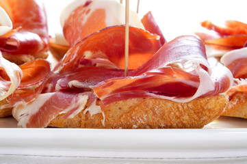 spanish pinchos de jamon, serrano ham served on bread