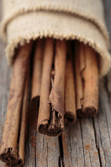 Cinnamon sticks on wooden background.