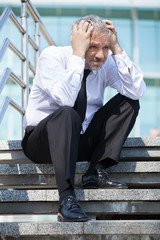 Depressed businessman. Depressed senior man in formalwear holdin