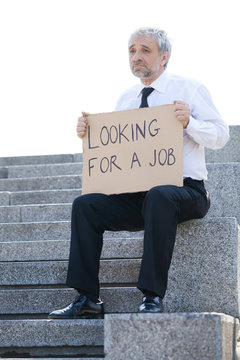 Fired man. Depressed senior man in formalwear holding poster Loo
