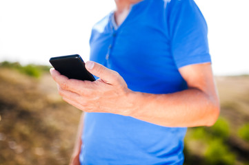 Young man using mobile smart phone, summer outdoor