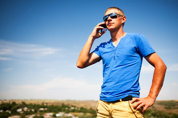 Young man using mobile smart phone, summer outdoor