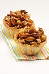 Cupcakes with caramelized nuts on white background