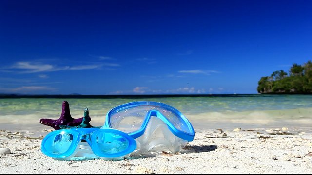 Swimming mask and starfish on caribbean beach