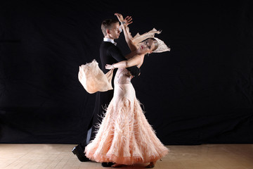 dancers in ballroom against black background