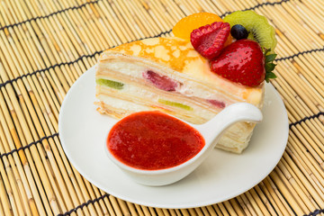crepes cake with orange, kiwi and strawberry sauce