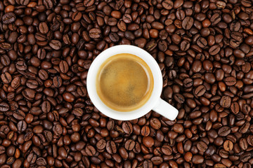 fine espresso in cup on coffee beans