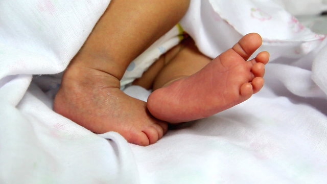 Closeup to cute newborn baby's feet , one week age