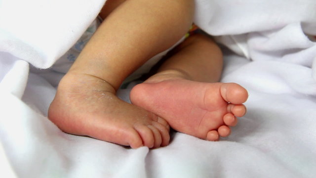 Closeup to cute newborn baby's feet , one week age