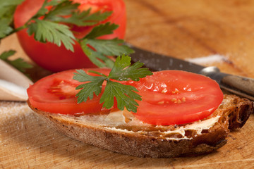 Slice of bread with butter and tomato.