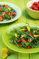 Mixed green salad with flower petals  and fresh strawberries