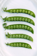 Opened green peas  pods on white background