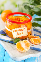 Orange jam with zest and tangerines, on blue wooden table