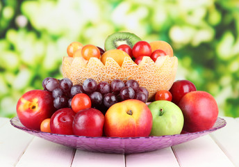 Naklejka na ściany i meble Assortment of juicy fruits on wooden table, on bright