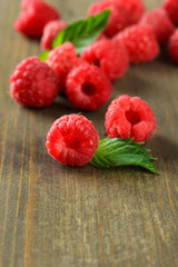 Ripe sweet raspberries on wooden background