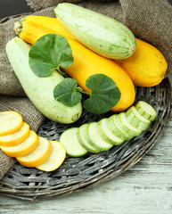 Sliced and whole raw zucchini on wooden table