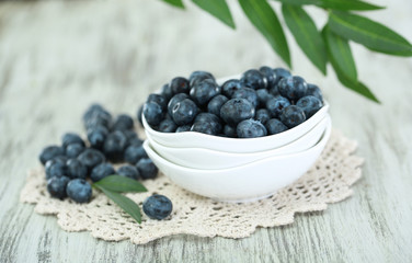Blueberries in plates on napkin on wooden background