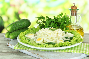 Delicious salad with eggs, cabbage and cucumbers on wooden