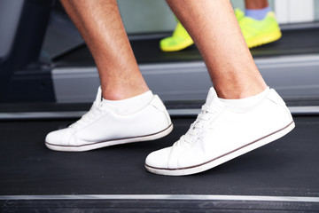 Fototapeta na wymiar Women and men feet on treadmill close-up