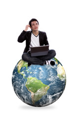 Portrait of business man  using laptop sitting on a globe isolat