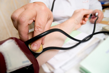 Doctor measuring blood pressure in hospital