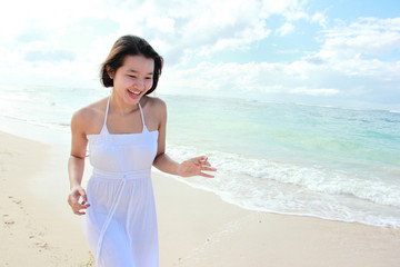Fototapeta na wymiar Young happy woman running on the beach