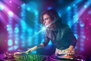Dj girl mixing music in a club with blue and purple lights