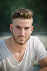 Portrait of handsome young man in white t-shirt outside