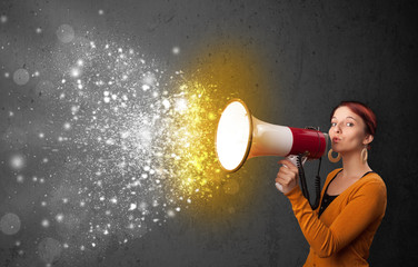 Woman shouting into megaphone and glowing energy particles explo