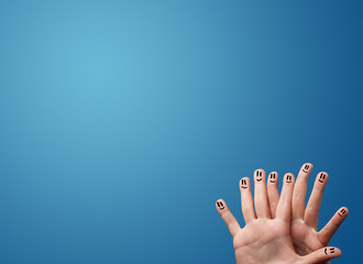 Happy smiley face fingers looking at empty blue background copy