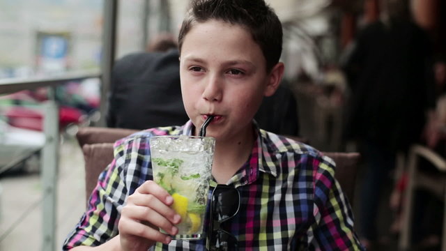 Young teenager drinking lemonade in cafe