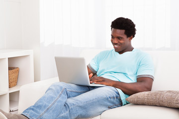 Happy Young Man Using Laptop