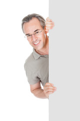 Happy Mature Man Standing Behind Placard