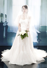 Fototapeta na wymiar full-length beautiful bridge in dress holding bouquet flower