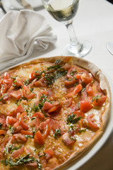 Delicious Italian pizza on a restaurant table with wine