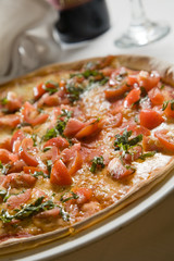 Delicious Italian pizza on a restaurant table with wine