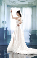 beautiful smiling girl in a white wedding dress posing
