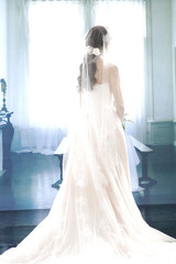 Obraz premium smiling girl in a white wedding dress back posing