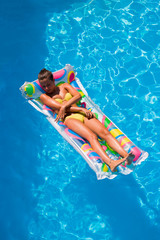 A girl is relaxing in a swimming pool